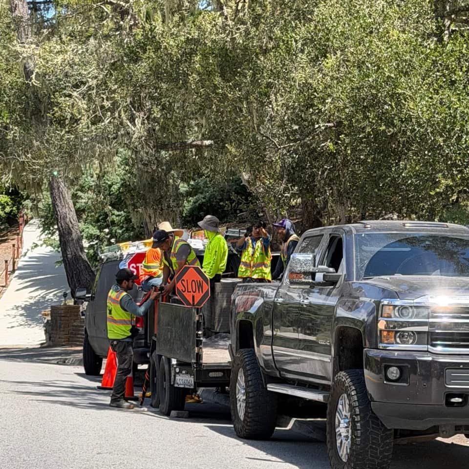 Green Angels crew and pickup truck staged on a tree-lined residential street